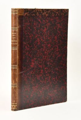an old book sitting on top of a white table next to a white wall