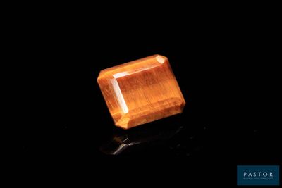 gros plan d'un diamant orange sur une surface noire