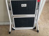 a black and white step stool next to a white wall