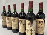 six bottles of wine are lined up in a row on a table