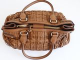 the brown purse is sitting on a white surface with a white background