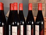 several bottles of red wine are lined up on a table