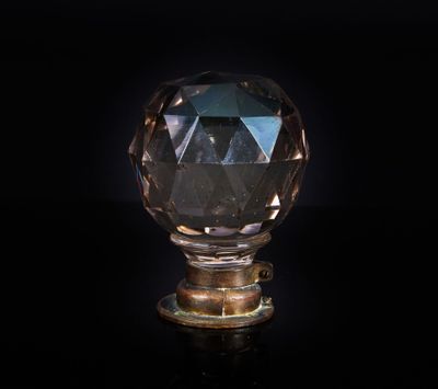 une image représentant un bouton en cristal sur une surface noire