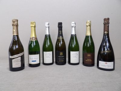 six bouteilles de vin sont alignées sur une table