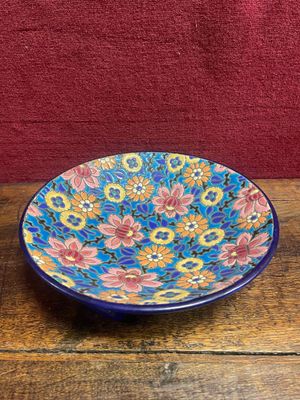 un bol bleu et rose posé sur une table en bois
