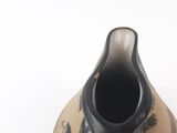 a black and white vase sitting on a white surface
