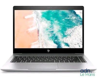 the laptop is open on a white surface with a beach in the background
