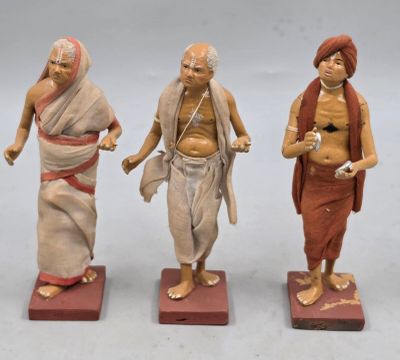 trois figurines représentant un homme, une femme et un enfant, posées sur des blocs de bois