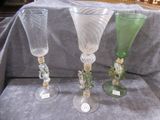 three wine glasses sitting on a table with a gray cloth