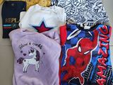 plusieurs vêtements d'enfants étalés sur un sol carrelé