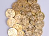 a pile of gold coins sitting on a white surface