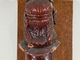 an image of a wooden carving of a man with a hat on his head