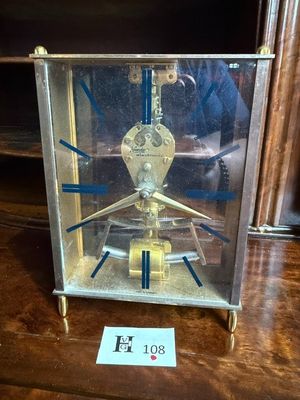 une horloge posée sur une table, sur laquelle est collé un autocollant