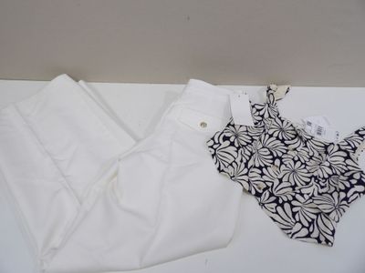 un haut noir et blanc et un pantalon blanc posés sur une table blanche