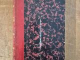 an old book sitting on top of a wooden table next to a knife