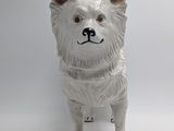 a white dog figurine that is standing on a table