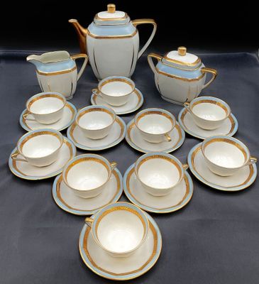 de nombreuses tasses et soucoupes posées sur une table, avec une théière
