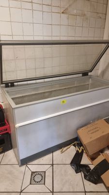 an image of a refrigerator sitting on top of a tiled floor next to boxes