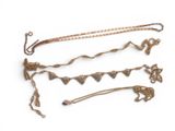 several pieces of gold jewelry are displayed on a white surface