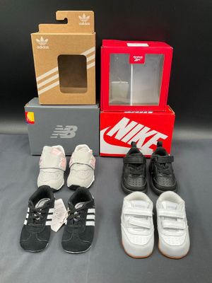 several pairs of shoes and a shoe box on a table