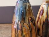 two vases that are sitting on a wooden table