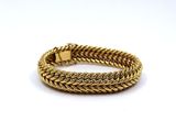 a gold bracelet on a white background