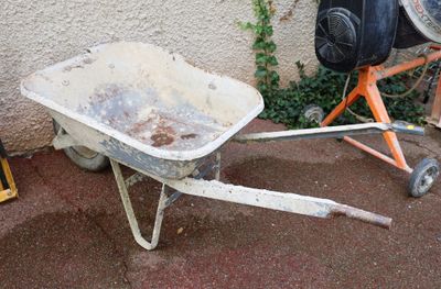 a wheelbarrow that is sitting on the ground next to a cement mixer