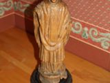 a statue of a man standing on a wooden floor