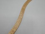 an image of a gold bracelet on a gray surface