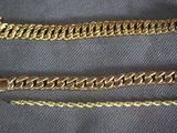 a close up of two gold chains on a black cloth