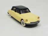 a yellow toy car with a black top on a white surface