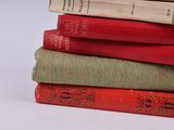 many books stacked on top of each other on a table