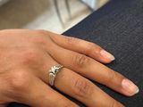 la main d'une femme, ornée d'une bague en diamant, posée sur un canapé
