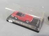 a red toy car in a clear box on a table
