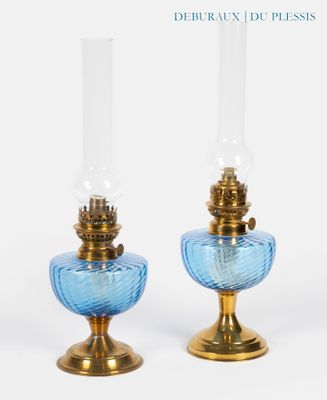 une paire de lampes en verre bleu montées sur des socles en métal doré, sur fond blanc