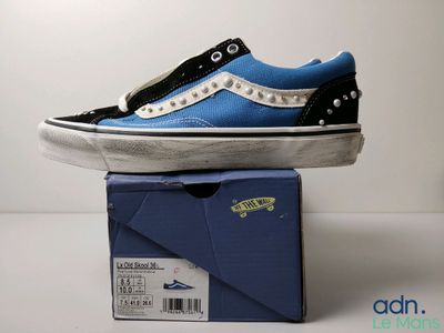 une paire de chaussures bleues et noires posée sur une boîte