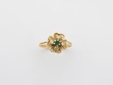 a gold ring with a green stone and white diamonds