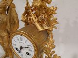une horloge en or avec un homme et une femme dessus