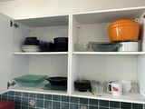 shelves above a sink in a kitchen with dishes and dishes on them