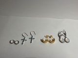 trois paires de boucles d'oreilles et une bague posées sur une table
