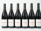 six bouteilles de vin sont alignées sur une table