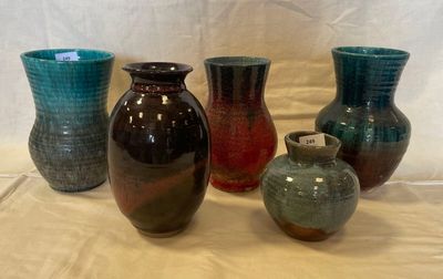 several different colored vases are lined up on a table
