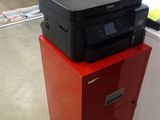 a printer sitting on top of a red filing cabinet