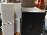 many different speakers sitting on a table in a warehouse