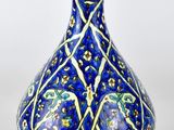 vase bleu et blanc orné d'un motif floral sur fond blanc