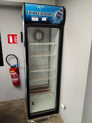 une photo d'un réfrigérateur dans une pièce où se trouve un extincteur