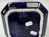 a blue glass clock with chinese writing on it