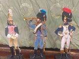 trois figurines de soldats exposées sur une table