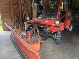 un tracteur rouge équipé d'une charrue