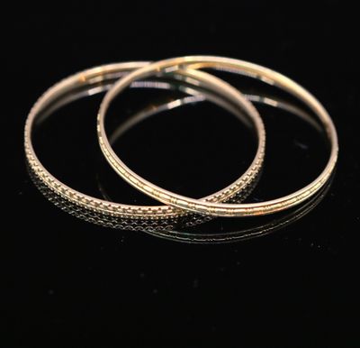 a pair of gold hoop earrings on a black surface